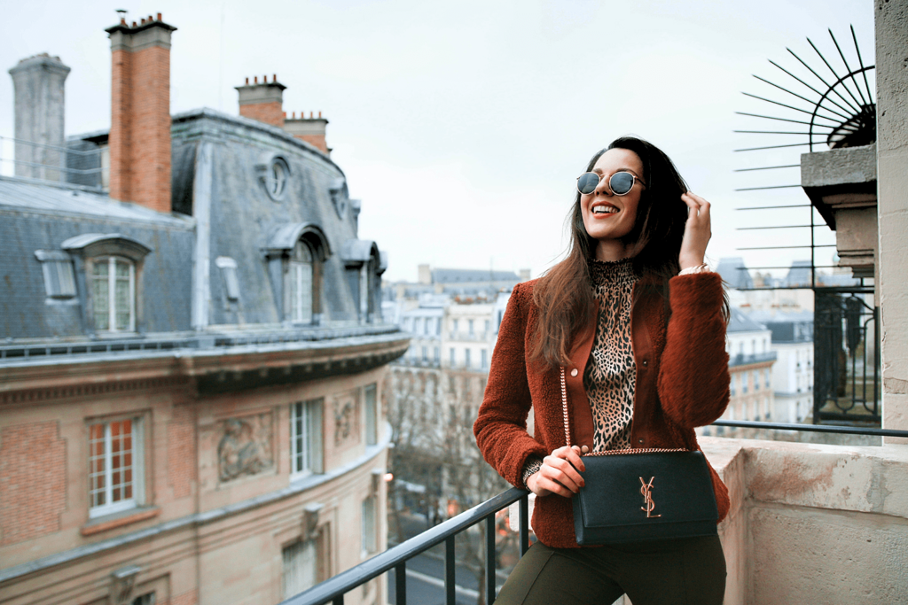 Une jeune femme à la mode prend la pose sur un balcon parisien pendant un week end shopping à Paris.
Visiter-Paris-en-2-jours-shopping