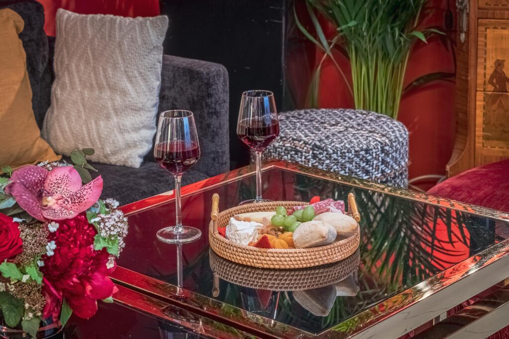 Service 4 étoiles dans notre hôtel rive gauche : plateau de fromage et de charcuterie avec deux verres de vin rouge