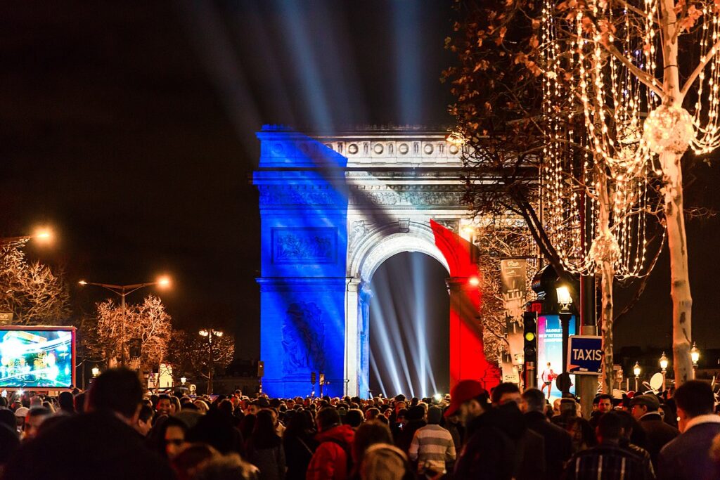 L'avenue des Champs-Elysées pour le Réveillon du Nouvel An. L'Arc de Triomphe est illuminé du drapeau français.